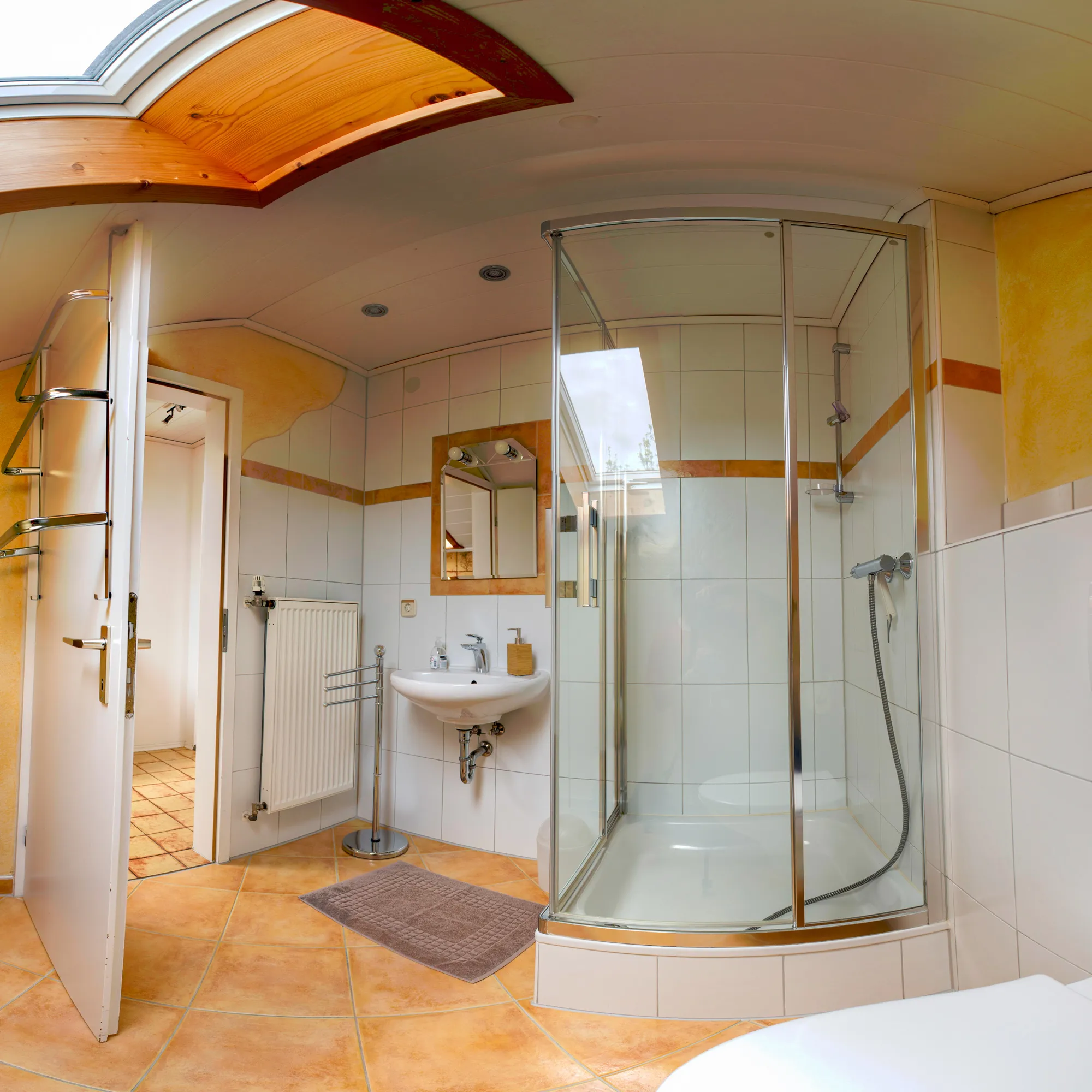 Badezimmer mit Dusche, Waschbecken und Dachfenster
