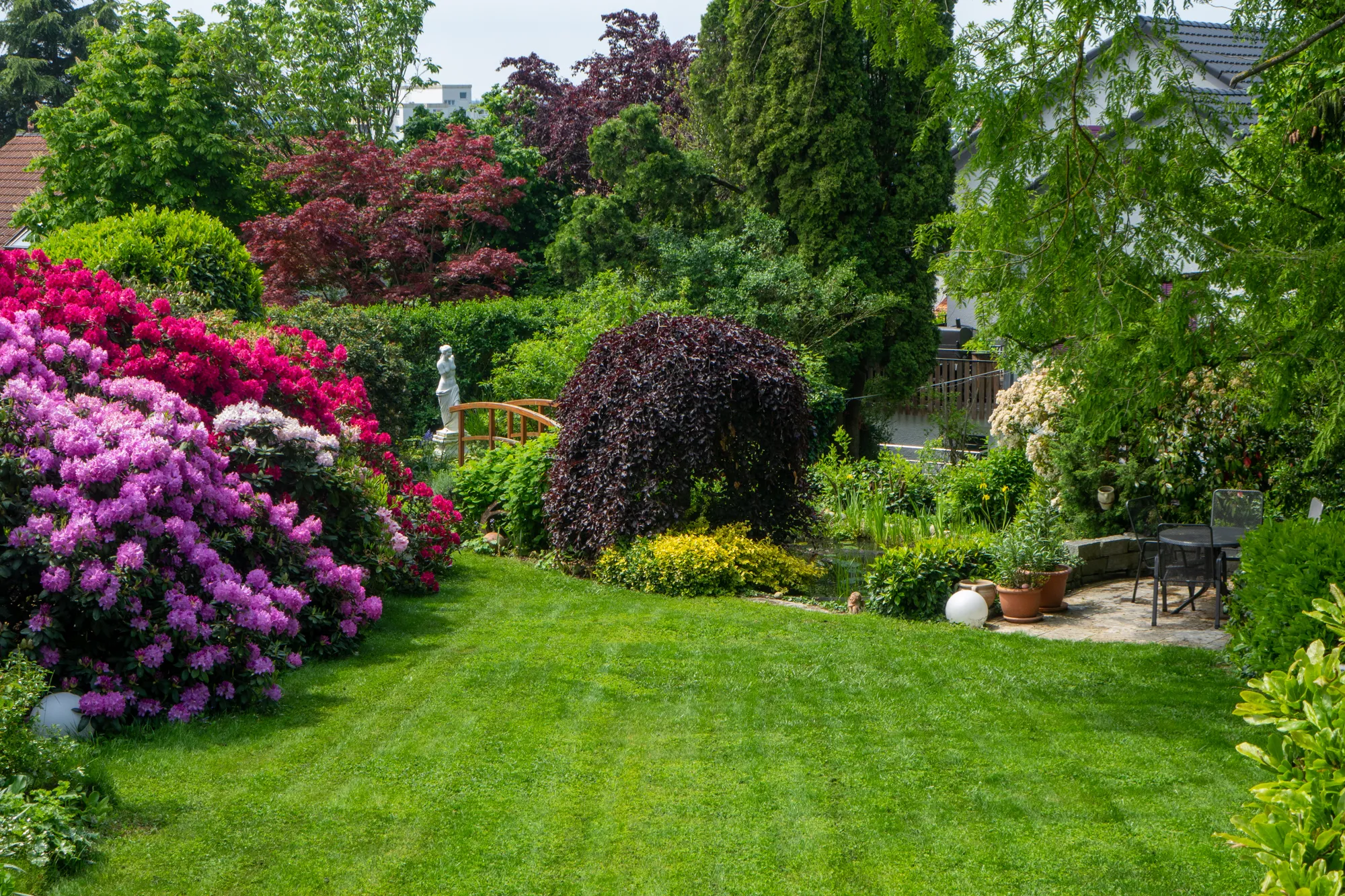 Gartensitzplatz zwischen Blumenbeeten